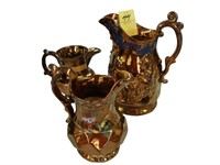 Three TOC, copper luster jugs