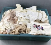 Lidless tote of doilies and other linens