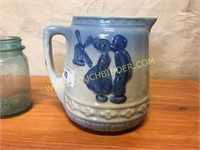 Antique glazed crock pitcher w/ dutch couple