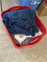 Red tote with lid filled with assortment of bed