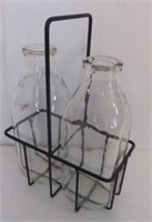 Wire milk carrier and two unmarked milk bottles.