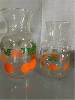 2 Vintage glass OJ Pitchers. 7 and 8 in