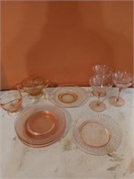 11 piece pink glass dish set, one plate has a chip