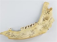 Bear jawbone with scrimshaw of various Alaskan ani