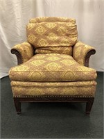 Upholstered chair with exposed armrest and skirt