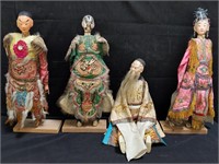 4 Asian dolls on wooden stands