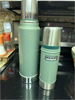 Two original green Stanley thermos