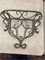 Fancy decorated iron wall shelf with a beveled