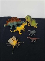 Group of dinosaur toys and a bee