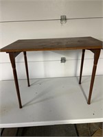 Antique child’s wooden table with fold up legs