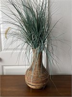 Faux plant in rattan vase