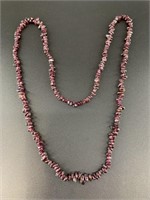 Long necklace of polished garnet beads.  31in circ
