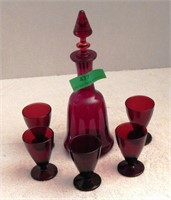 Red glass decanter, five wine glasses