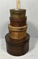 Four vintage round storage boxes in graduated size