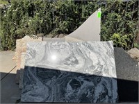 A collection of granite and marble slabs.