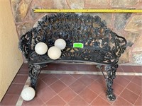 Cast-iron garden bench with four stone globes