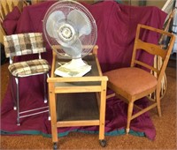 Two-tier cart on wheels, two chairs, and desk fan