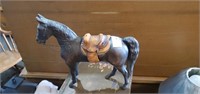 Solid metal horse with leather saddle