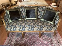 Antique floral upholstered settee with wooden