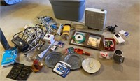 Grey tub of power cords, picture frames, fan,