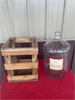 Large glass jug, and wooden crate