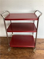 Red metal utility cart, chrome handles, on wheels