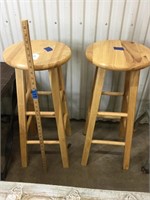 Two light wooden bar stools