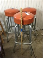 Three retro orange vinyl & metal swivel stools