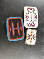 Three intricately beaded belt buckles in Native Am