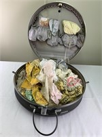 Round luggage filled with linens & doilies