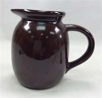 Brown 6" tall pitcher with handle.