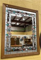 Framed wall mirror with applied floral border.