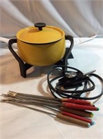 Yellow fondue pot with fondue forks