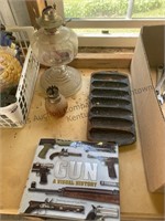 Oil lamps, cast iron muffin pan and gun book.