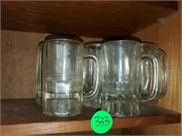 SHELF OF GLASS BEER MUGS