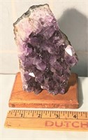 Amethyst purple crystal geode on stand