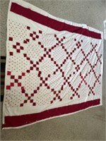 Handmade red and white tact quilt. Appears to be
