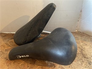 Pair of bicycle seats. One has the stem.