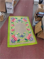 Tan rug with green border and flowers  39" x 62"
