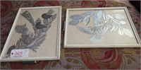 Pair of silver colored foil artworks under