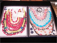 Two trays of colorful costume jewelry including