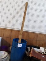 Blue metal trash can with a ruler