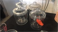 4 clear canister jars w lids. One is chipped