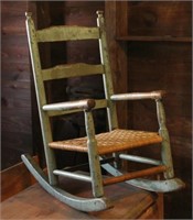 Child's woven seat arm chair in green paint,