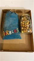 Bag of glass marbles and jar of wooden marbles