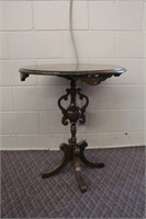 Round table with carved legs and ornate pedestal,