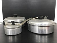 Three vintage aluminum pots with lids