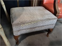 Upholstered ottoman with wood legs, slight wear.