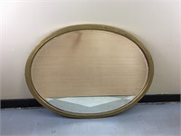 An oval gold rimmed mirror