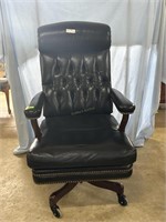 Black leather executive office chair on casters